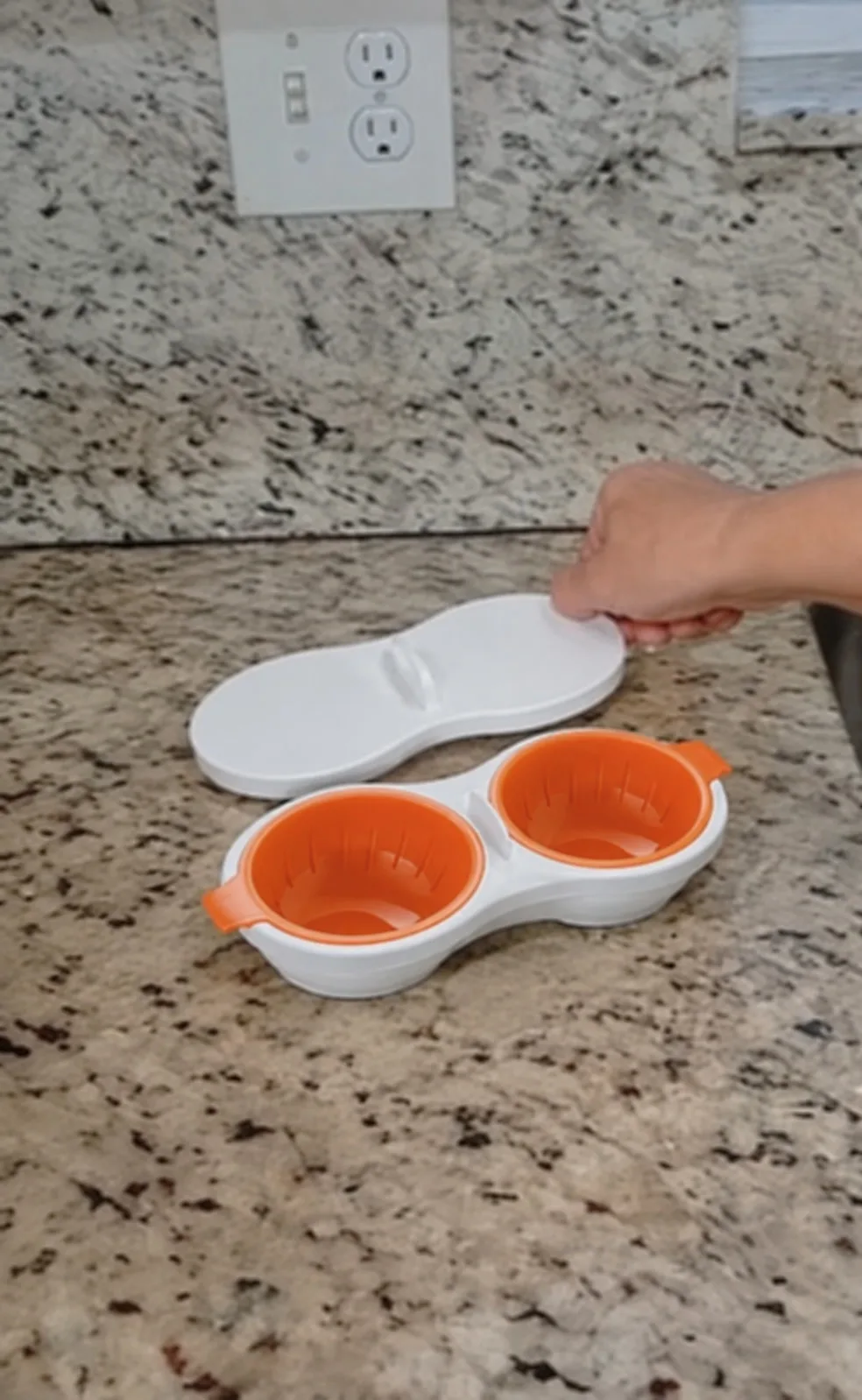 Pochador blanco con canastillas naranjas y tapa al lado, en un mesón de cocina