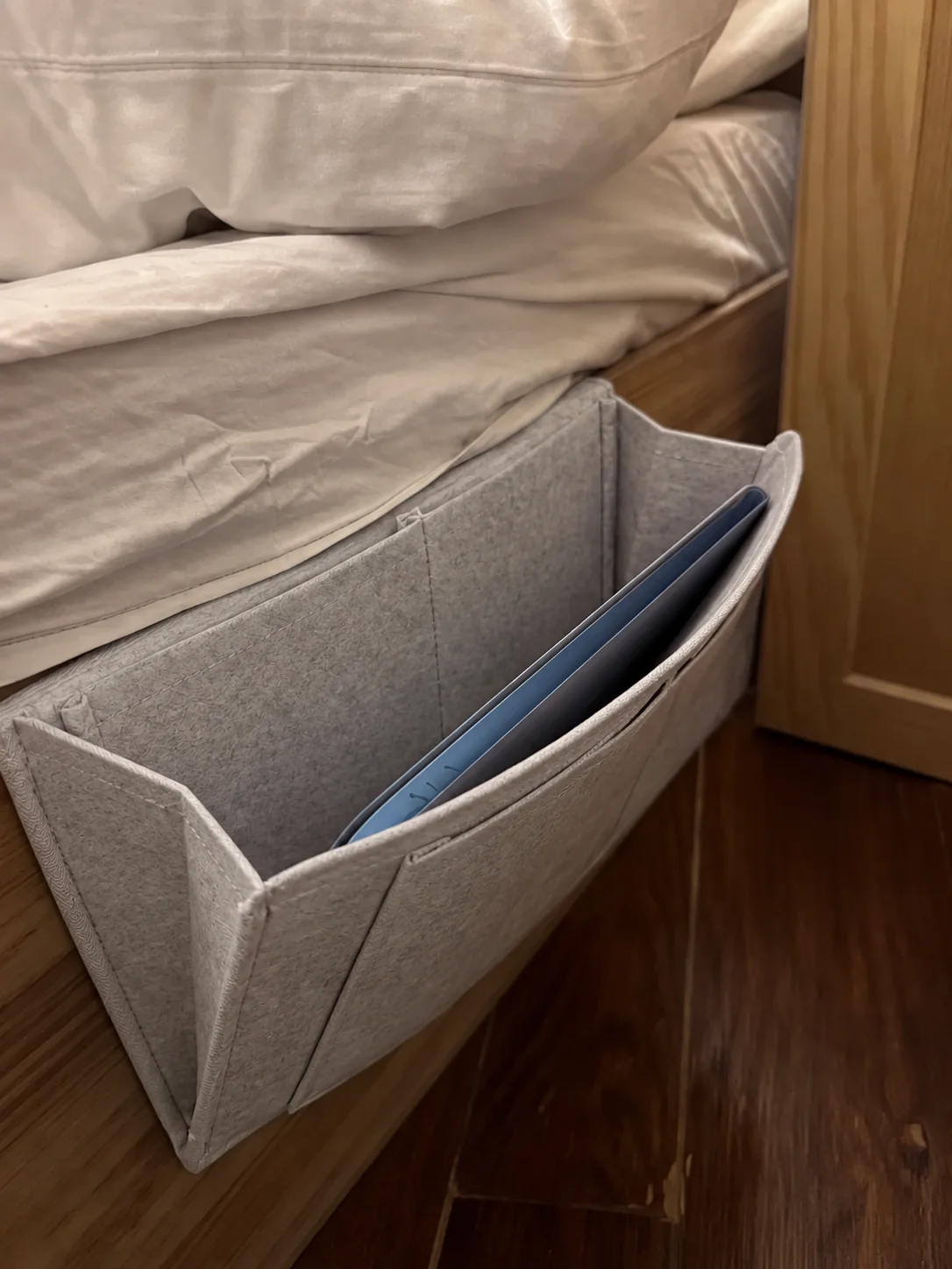 Organizador con una carpeta en el bolsillo lateral de la cama