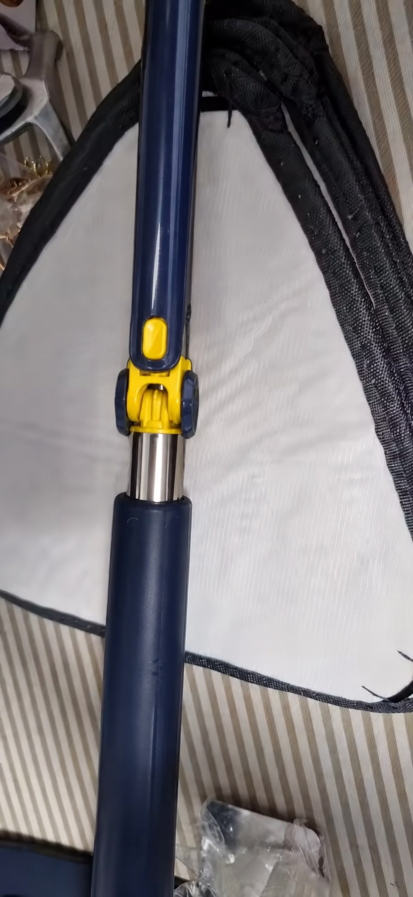 Detalle de la articulación amarilla del mango del trapero triangular 360°